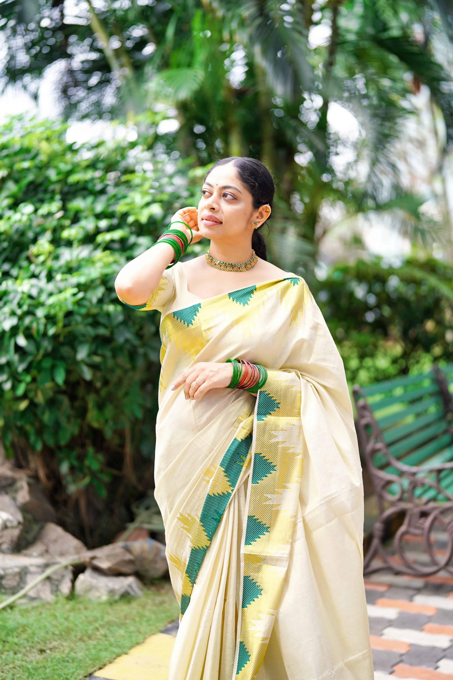 A Women wearing Golden Tissue Saree with Green Temple Motifs