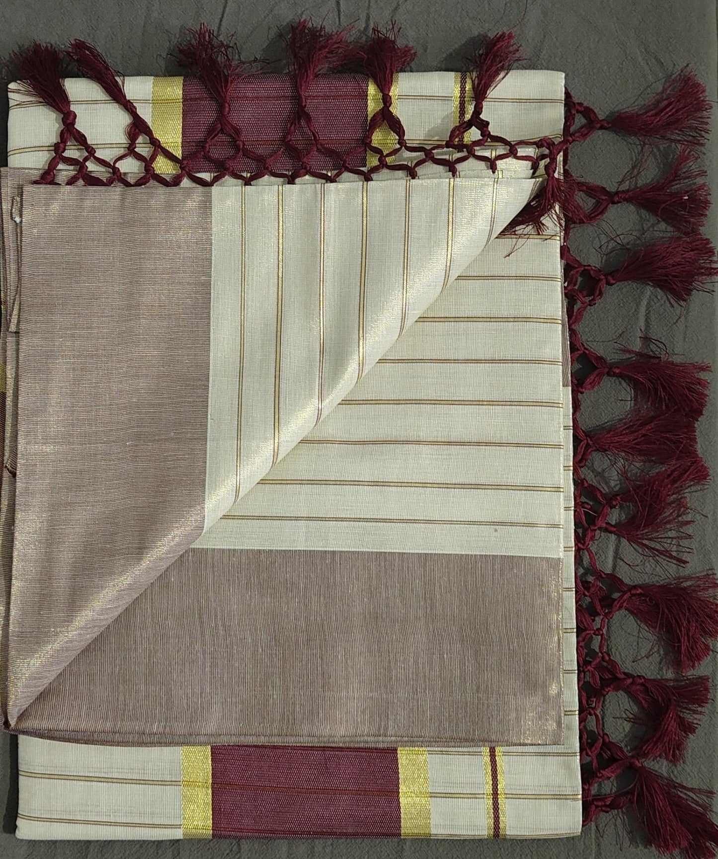 Folded fabric with decorative tassels on a gray background