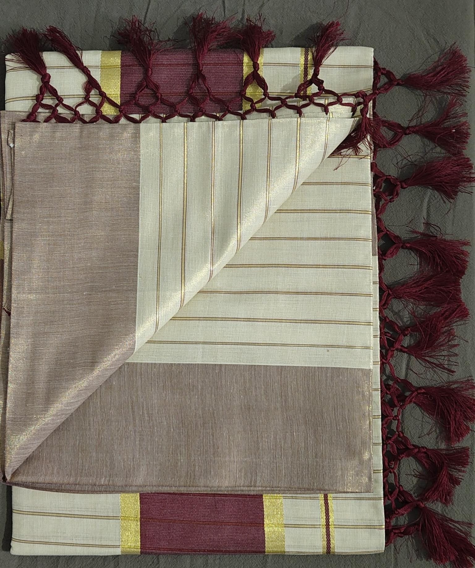 Folded fabric with decorative tassels on a gray background