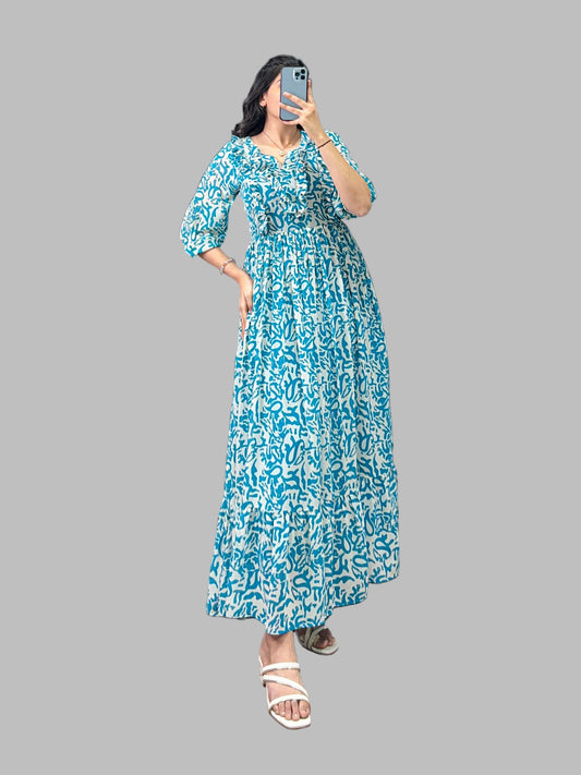 Woman taking a mirror selfie wearing a blue floral dress in an indoor setting.