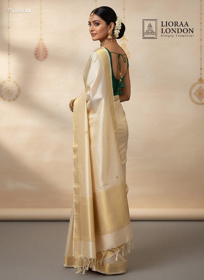 Lioraa London Ltd cream silk saree with gold border and emerald green sleeveless blouse featuring a back tie-up detail.